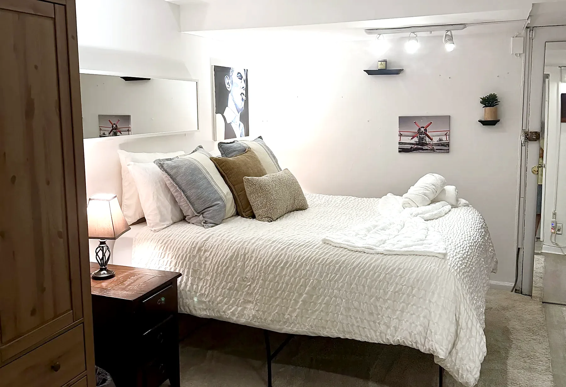 Second bedroom in 2026: queen bed, white walls, track lighting