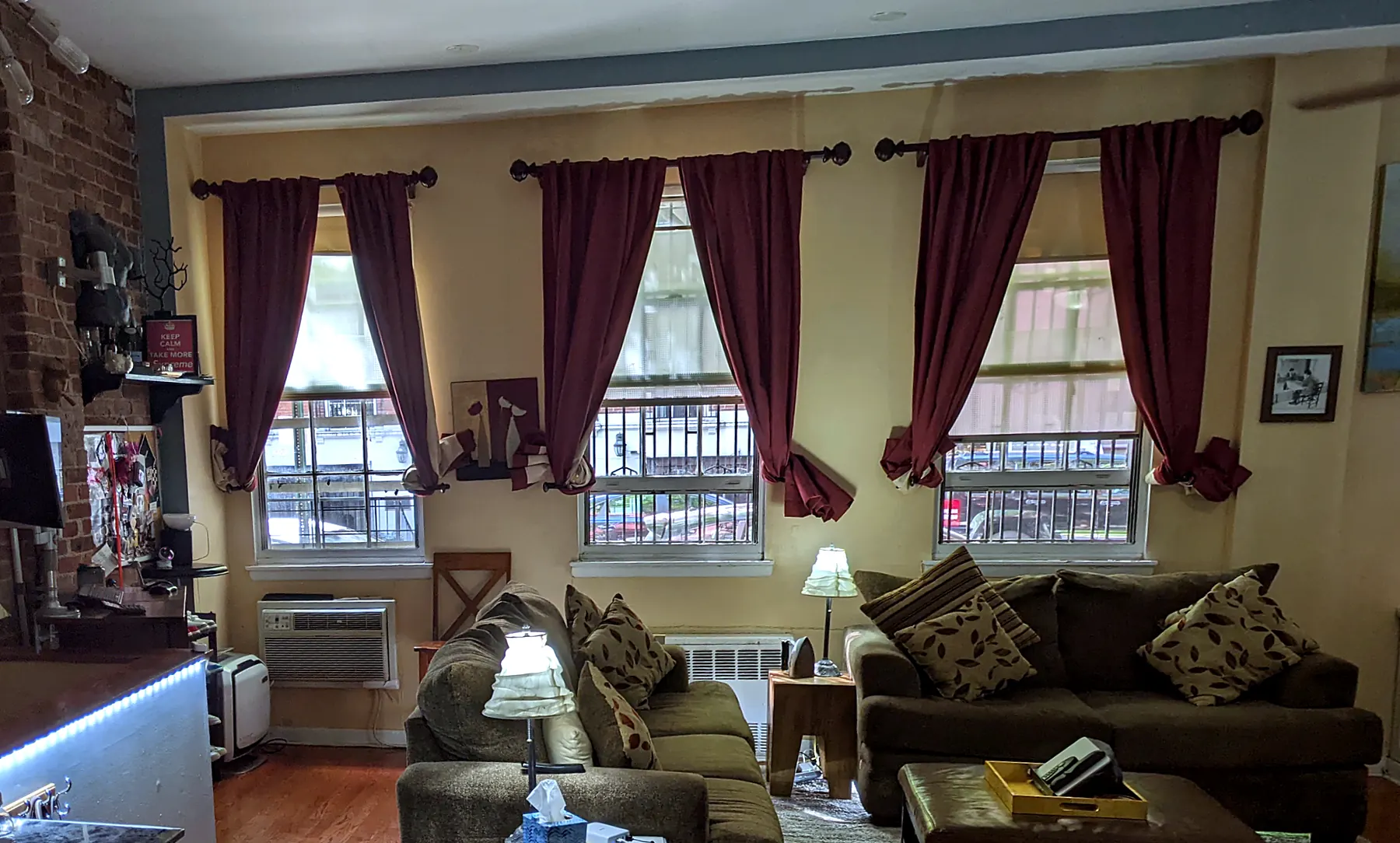 Living room windows in 2022: maroon curtains, yellow walls, brown sofas