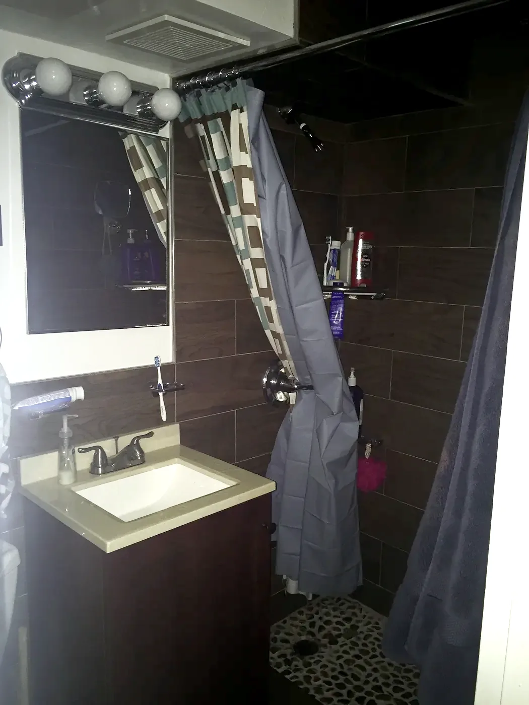The bathroom in February 2016: wood-look tile, dark vanity with a stone top, new faucet