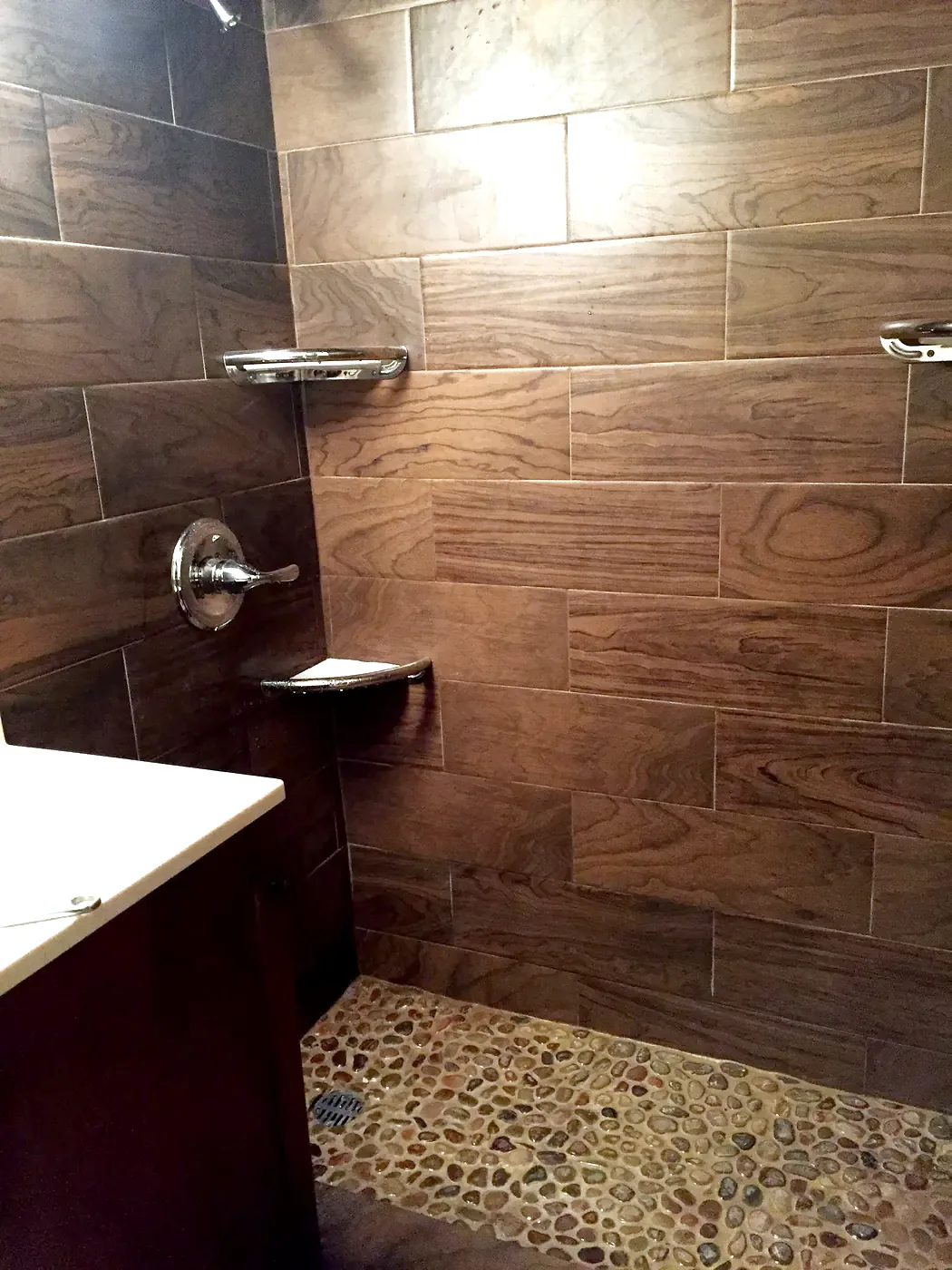 New shower in 2016: wood-look tile walls and river rock floor